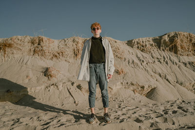 Portrait of young man standing on sand