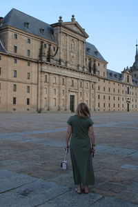 Full length rear view of woman against building in city