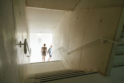 Rear view of people walking in corridor of building