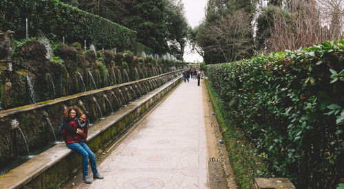 Couple sitting on railing with people in background