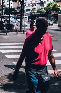 Rear view of man and woman walking on road