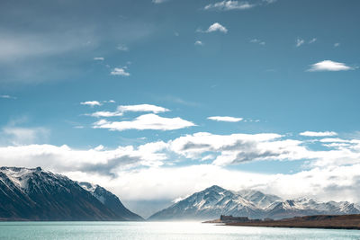 A scenic landscape of new zealand southern alps and lake tekapo with blue sky and clouds.