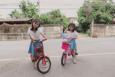 Little girls enjoy bike ride outdoor