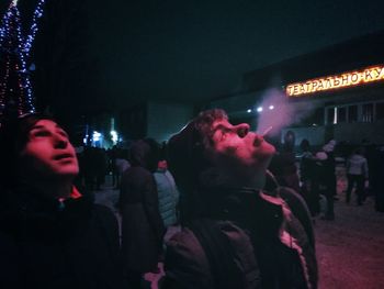 People on illuminated street at night