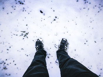 Low section of man standing on snow