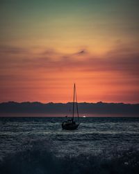 Silhouette sailboat on sea against sky during sunset