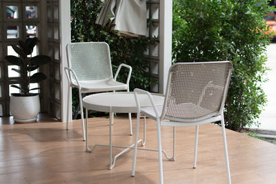 Empty chairs and tables against building