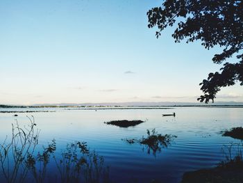 Scenic view of lake against sky at sunset