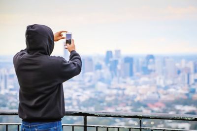 Rear view of man photographing cityscape