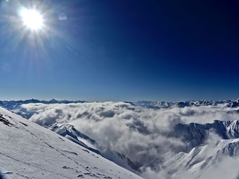 Scenic view of snowcapped mountains against blue sky