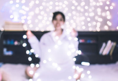 Young woman with illuminated lights at night