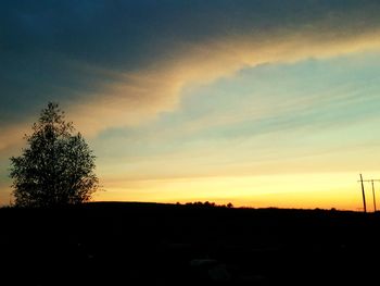 Silhouette landscape against dramatic sky during sunset