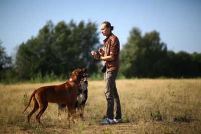 Man with dog standing on field