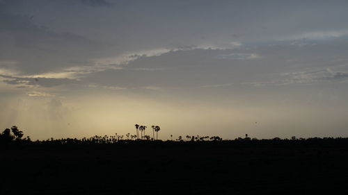 Scenic view of silhouette field against sky at sunset