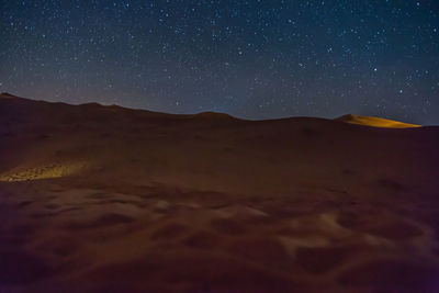 Scenic view of desert against clear sky at night