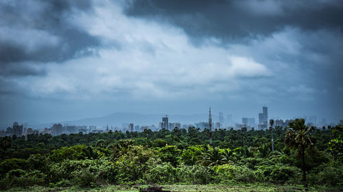 View of cityscape against cloudy sky