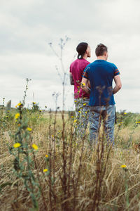 Rear view of couple standing on field