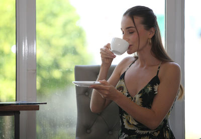 Young woman drinking coffee at home