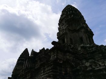 Low angle view of buddha statue against cloudy sky