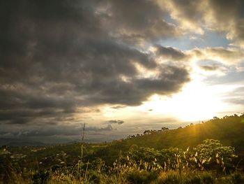 Scenic view of field against dramatic sky