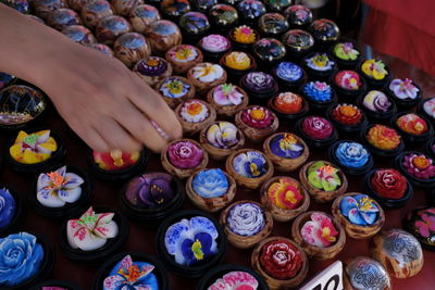 Cropped hand buying colorful flowers