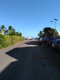 Cars on road against clear blue sky