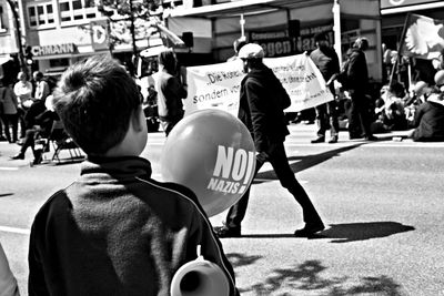 Rear view of people walking on city street