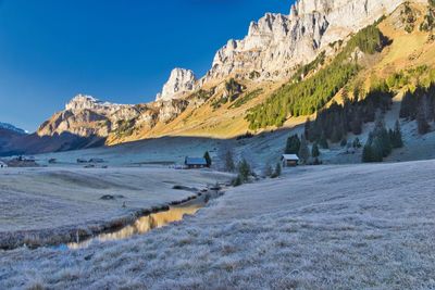 Scenic view of snowcapped mountains against clear blue sky