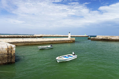 Boats moored at calm blue sea