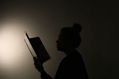 Side view portrait of silhouette man standing against gray background