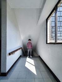 Rear view of woman standing on tiled floor in building