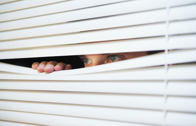Close-up of human hand on window blinds