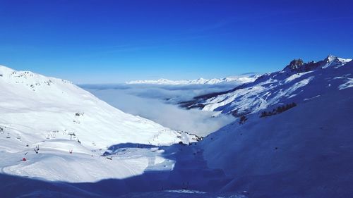 Scenic view of snowcapped mountains against clear blue sky