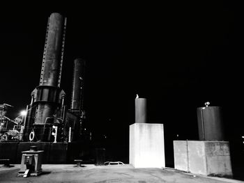 Low angle view of smoke stack against sky at night