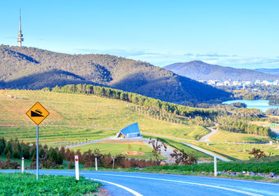 Road by mountains against sky