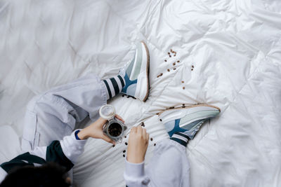 Low section of woman standing on bed