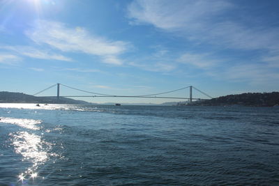 Bosphorus bridge in sea against cloudy sky