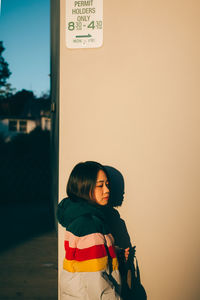 Woman standing by building in city