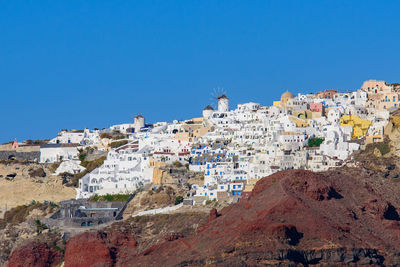 Buildings in town against clear blue sky