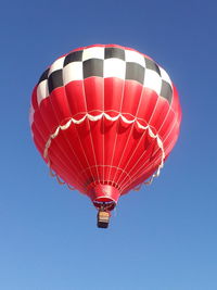 Low angle view of hot air balloon against clear blue sky