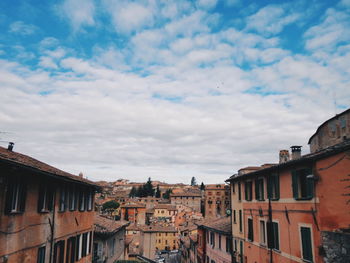 Buildings in city against cloudy sky