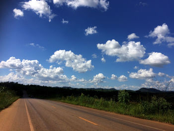 Road amidst field against sky