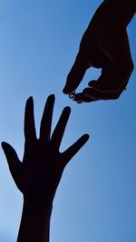 Low angle view of hand against clear sky
