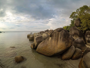 Close-up of rocks in sea against sky