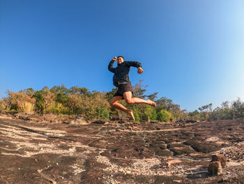 Full length of man jumping against clear sky