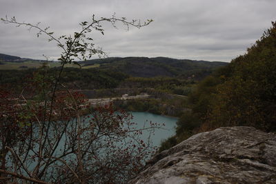 Scenic view of lake by mountains against sky