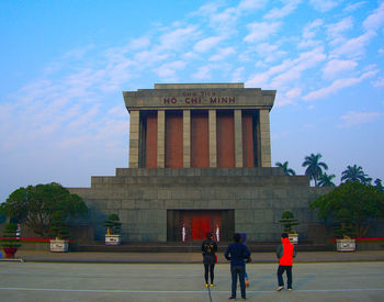 People in front of historical building against sky