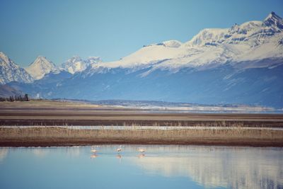 Scenic view of lake and snowcapped mountains against sky