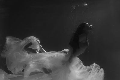 Woman with curtain swimming in pool