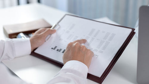 Midsection of businessman working on table